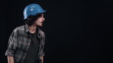 Mühendisin mavi miğferli karizmatik çocuğu parmağını bir tarafa doğrultur, hevesle bakar ve 