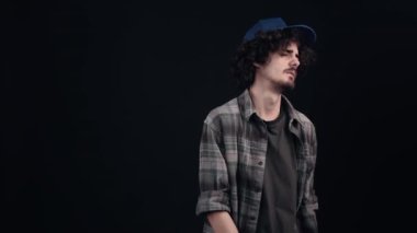 Mavi şapkalı genç, kıvırcık hippi üzgün ve üzgündü, ağlamak istiyordu ama gururu gitmesine izin vermiyordu, üzüntünün kaynağını bir tarafa itiyordu. Siyah arka planda izole edilmiş. Şey...