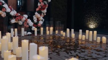 Aşk tapınağında parlak yapraklar serpiştirilmiş mumlar ve güllerden yapılmış büyük bir kalp var. Aşk kavramı. 4K portresi