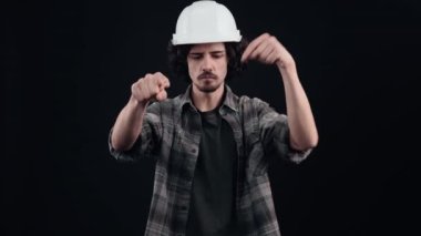 Mühendisin beyaz miğferindeki ciddi, otoriter çocuk işaret parmağıyla onu işaret ediyor. Sonra da en yakınındaki yere geliyor. Buraya gel. Siyah arka planda izole edilmiş. Şey...