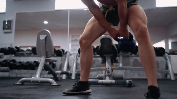 Gefilmd frame van de atleten benen uitvoeren sit-ups met een gewicht dat hij omhoog tilt. Intense mannelijke energie. Een gezonde levensstijl. Sport concept — Stockvideo