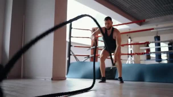 Close-up do jovem treinador mostrando como executar o exercício com cordas de luta. Exercício de intensidade máxima. Estilo de vida saudável. Conceito de desporto — Vídeo de Stock