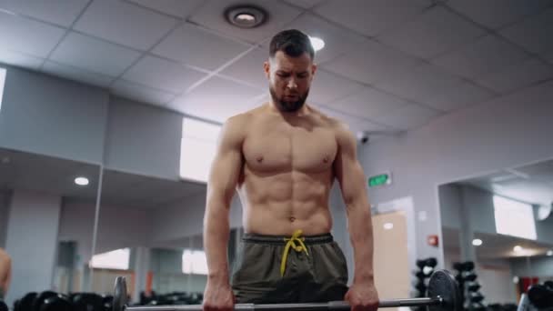 Een gespierde jongeman met stijve benen en lange halters in de sportschool. Intense mannelijke energie. Een gezonde levensstijl. Sport concept — Stockvideo