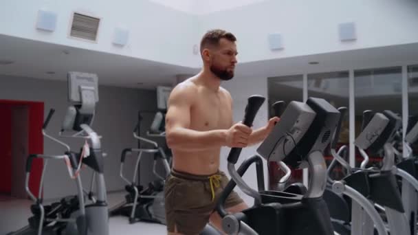De ambitieuze bodybuilder traint op de crossmotor in de sportschool. Intense mannelijke energie. Een gezonde levensstijl. Sport concept — Stockvideo