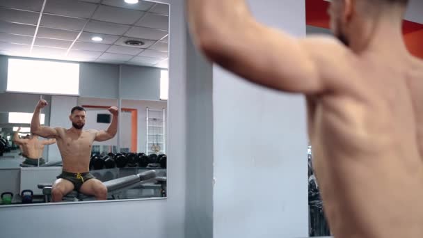 Ramen filmas i spegeln, där den självsäkra idrottaren spänner musklerna. Intensiv maskulin energi. En hälsosam livsstil. Idrottsbegreppet — Stockvideo