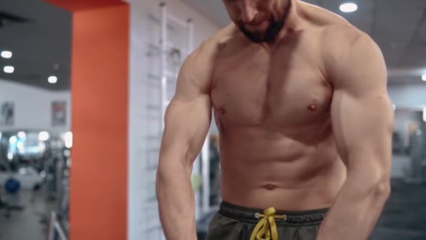 O quadro de um homem no peito tenso com as mãos musculares no ginásio. Intensa energia masculina. Estilo de vida saudável. Conceito de desporto — Vídeo de Stock