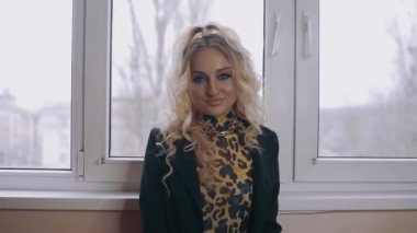 Kıvırcık saçlı, sert makyajlı, gülümseyen gözleriyle önümüze bakan sarışın kadın. Kadınsı enerji. Güzellik endüstrisi. Sanatsal kavram