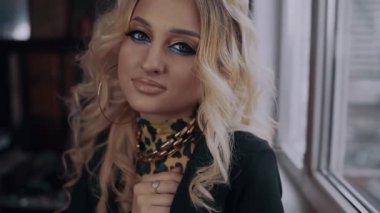 Cırtlak makyajlı nazik ve güzel sarışın parmaklarını çenesinin altına koyar ve onları şehvetle yürütür. Kadın enerjisi. Güzellik endüstrisi. Sanatsal kavram