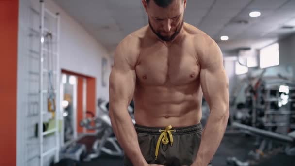 Quadro de um homem musculoso que tensiona os músculos nas mãos e costas. Intensa energia masculina. Estilo de vida saudável. Conceito de desporto — Vídeo de Stock