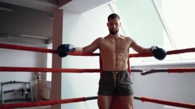 Savaş meydanının köşesinde oturan ciddi, eğitimli bir gencin portresi. Maksimum yoğunluk egzersizi. Sağlıklı bir yaşam tarzı. Spor konsepti