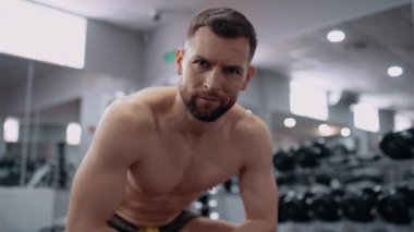 Spor salonundaki bir sporcunun portresi ileride tehlikeli ve seksi görünüyor. Yoğun erkeksi enerji. Sağlıklı bir yaşam tarzı. Spor konsepti
