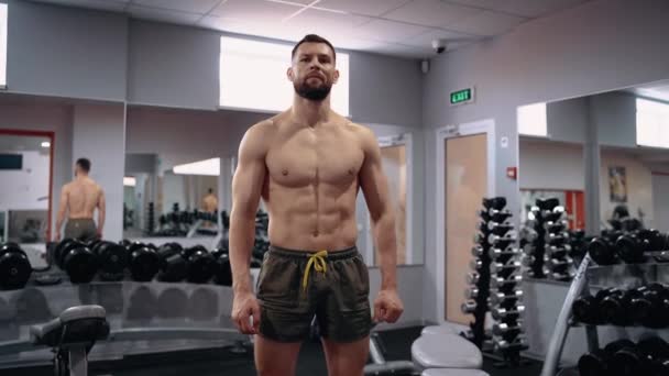 Das Porträt eines muskulösen Mannes mit nacktem Oberkörper in der Turnhalle blickt in die Kamera. Intensive männliche Energie. Gesunder Lebensstil. Sportkonzept