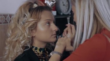 Makyöz, gözün içini pamuklu bezle temizliyor. Bir profesyonelin evde makyaj yapma süreci. Sanatsal kavram