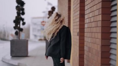 Karizmatik genç kadın, profesyonel makyajlı sarışın ve mutlu bir şekilde yürüyor. Kadın enerjisi. Güzellik endüstrisi. Sanatsal kavram