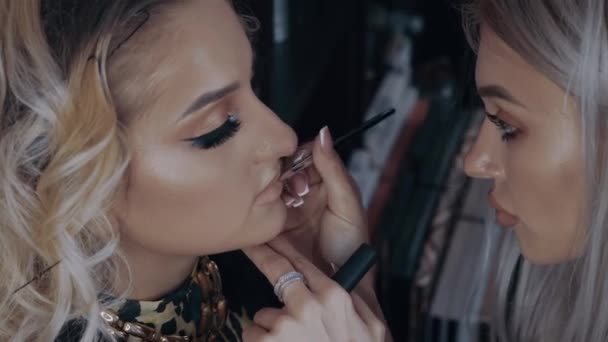 Make-up artist contours the upper lip with the brush and light brown lipstick. The process of applying makeup at home by a professional. Beauty industry. Artistic concept — Stock Video