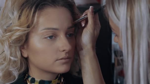 Il make-up artist accentua la meravigliosa forma delle sopracciglia contorcendole con correttore. Il processo di applicazione del trucco a casa da un professionista. Concetto artistico — Video Stock