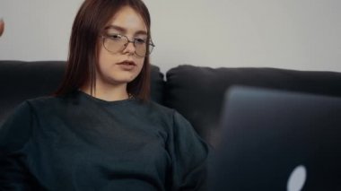 İnternette konuşan gözlüklü genç kızıl saçlı bir iş görüşmesinin ortasında iş başvurusunda bulunuyor. Yetenekleri ve planları hakkında konuşuyor. Koyu yeşil bir bluz giyip siyah bir kanepede oturuyor. Konsept