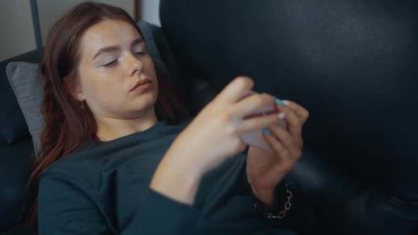 Cadre d'une jeune femme relaxante, jouant à des jeux vidéo au téléphone. Le concept du joueur. Concept 4k — Video