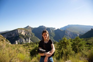 Genç fotoğrafçı bir portre için poz veriyor. Genç bir fotoğrafçı kameraya poz veriyor. Fransa 'nın Gorges du Verdon kentindeki vahşi yaşam fotoğraf çekiminde..