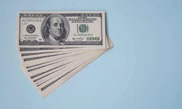 Um pacote de notas de cem dólares num fundo azul. Negócios — Fotografia de Stock