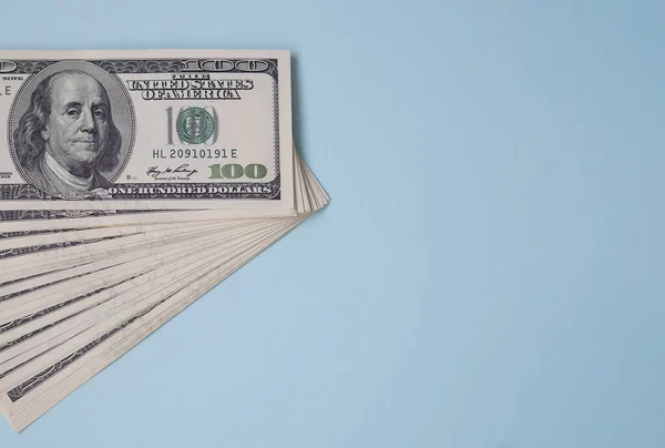Um pacote de notas de cem dólares num fundo azul. 100 EUA — Fotografia de Stock