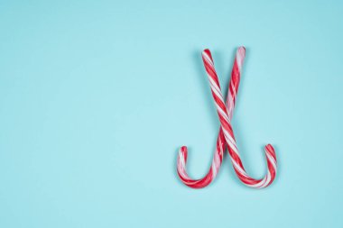 Açık mavi arkaplanda iki baston şeker