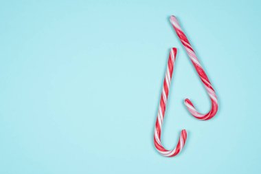 Açık mavi arkaplanda iki baston şeker