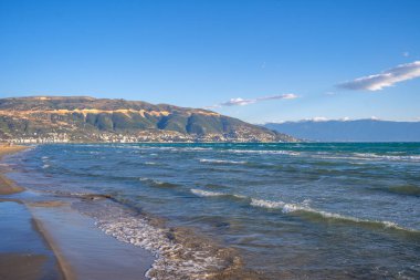 Yaz tatili kavramı. Köpüklü bir deniz dalgası kuma düşer. Seyahat kavramı