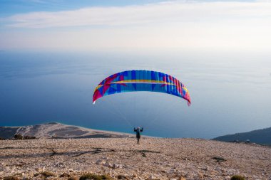 Paraglider başlıyor. Paraşüt, güneşli bir günde Alp dağlarında havayla doluyor.