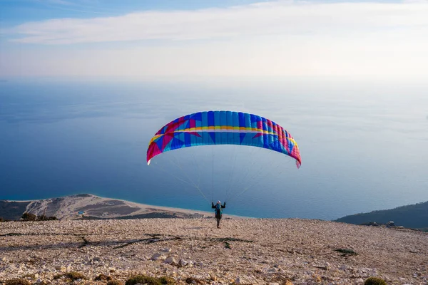 Paraglider başlıyor. Paraşüt, güneşli bir günde Alp dağlarında havayla doluyor.