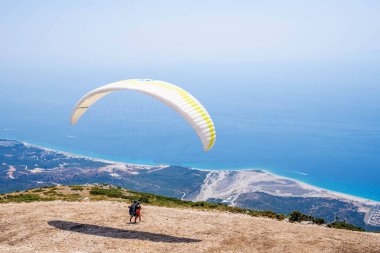 Paraglider başlıyor. Paraşüt, güneşli bir günde Alp dağlarında havayla doluyor.