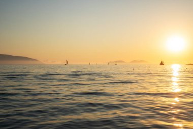 Gün batımında ufukta bir sürü yat var.