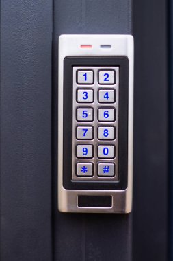 Koyu metal bir yüzey üzerinde mavi numara tuşları olan gümüş dahili telefon paneli