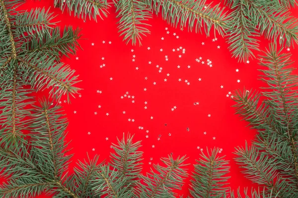 Ramas Árbol Navidad Sobre Fondo Rojo Con Estrellas Confeti Plateadas —  Fotos de Stock