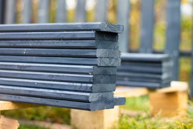 Koyu gri bir çit levhaları dışarıda, kısmen bulanık.