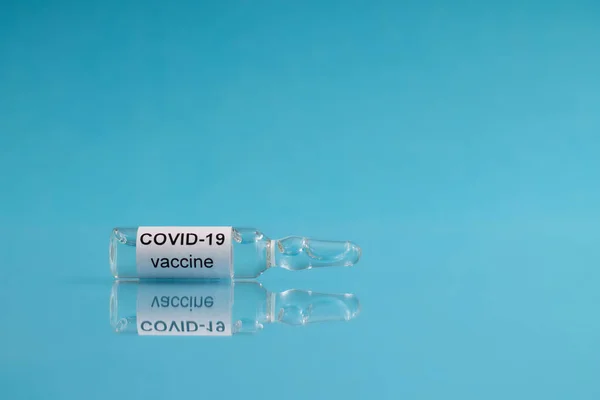 Μια Φύσιγγα Εμβόλιο Covid Coronavirus Βρίσκεται Μπλε Φόντο Αντίγραφο Χώρου — Φωτογραφία Αρχείου