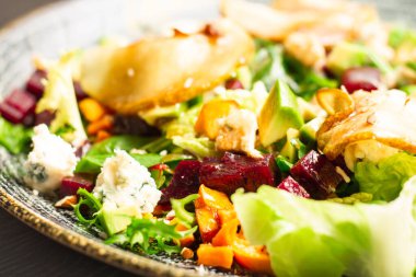 Karamelli armut, pancar, roka, avokado, havuç ve dorblu peynirli sebze salatası.