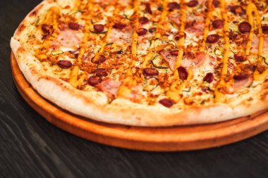 Tahta masadaki yuvarlak tepside Bavyera pizzası.