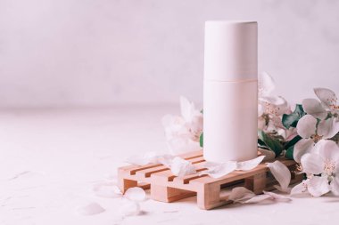 Ahşap podyumda terleme önleyici deodorant. Elma çiçekleriyle sıva yüzeyinde palet şeklinde. Boşluğu kopyala