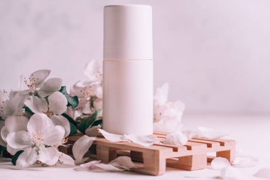 Ahşap podyumda terleme önleyici deodorant. Elma çiçekleriyle sıva yüzeyinde palet şeklinde. Boşluğu kopyala