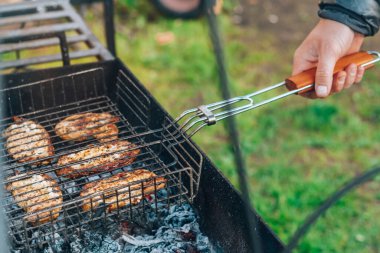 Erkek el mangalda ızgarada pişmiş ızgara ete dönüşür. Açık havada barbekü yapmak.