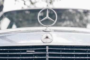 1980 'lerden kalma eski beyaz Mercedes E sınıfı 200D. Logo işareti ve radyatör ızgarasının bir kısmı. Minsk, Belarus - 30.06.21