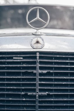 1980 'lerden kalma eski beyaz Mercedes E sınıfı 200D. Logo işareti ve radyatör ızgarasının bir kısmı. Dikey. Minsk, Belarus - 30.06.21