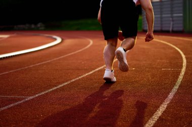 Sporcu koşu pistinde koşuyor.               