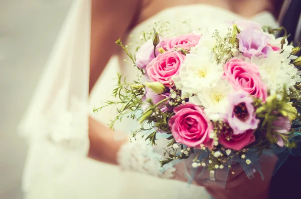 Handen en ringen op bruiloftsboeket — Stockfoto