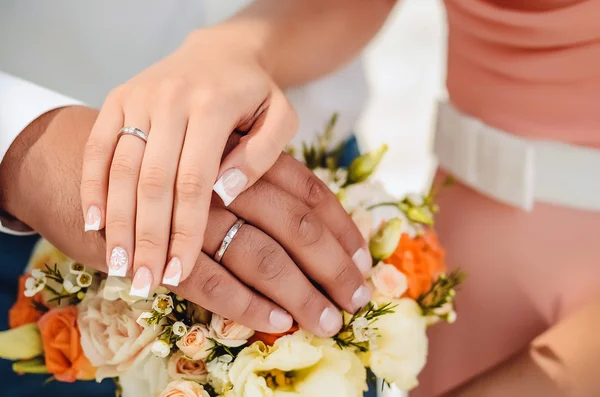 Hands and rings on wedding bouquet Royalty Free Stock Photos