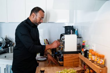 Evde kahve yapan yakışıklı adam.