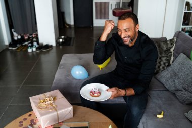 Virüs salgını ve sosyal etki: 40 yaşındaki bir adam evinde doğum gününü kutlarken ailesiyle konuşmak için bilgisayarını kullanıyor.