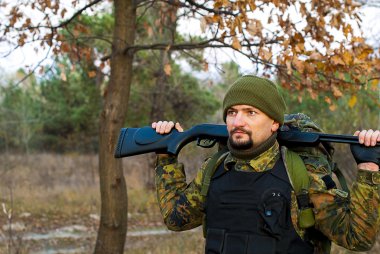 Bir tüfek sonbahar ormandaki askerle