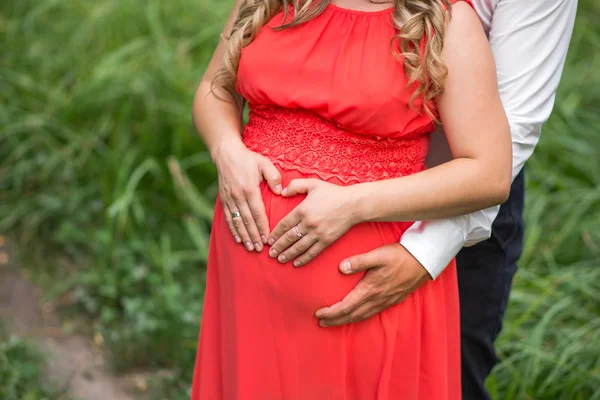 Brzuch w ciąży dziewczynka w czerwonej sukience na charakter — Zdjęcie stockowe